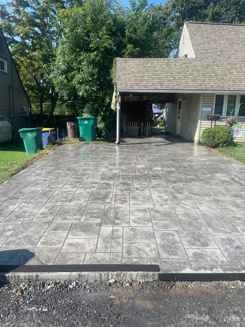 Stamped concrete driveway under a carport