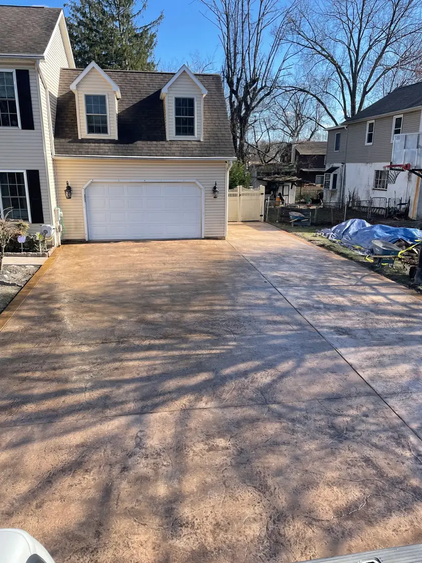 Tan stamped concrete driveway in front of a two-car garage