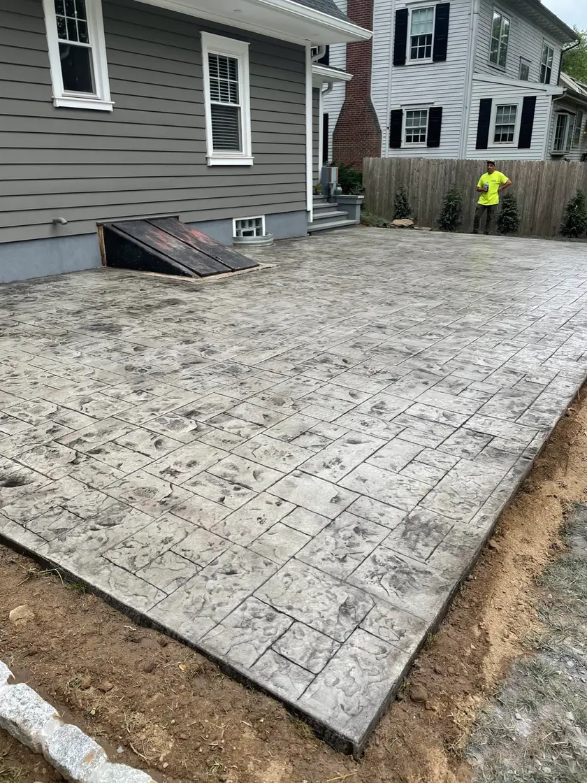 Gray stamped concrete patio behind a home