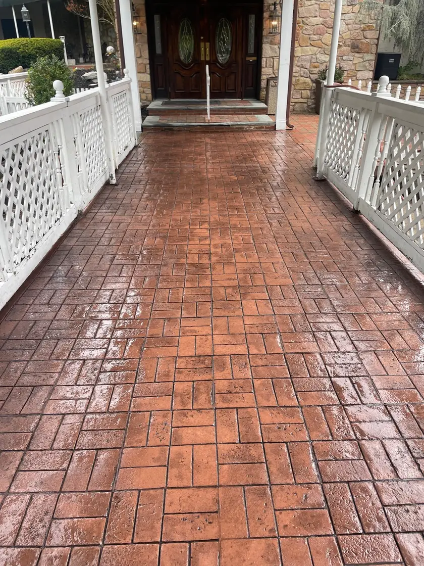 Stamped brick-pattern concrete walkway leading to a front entrance